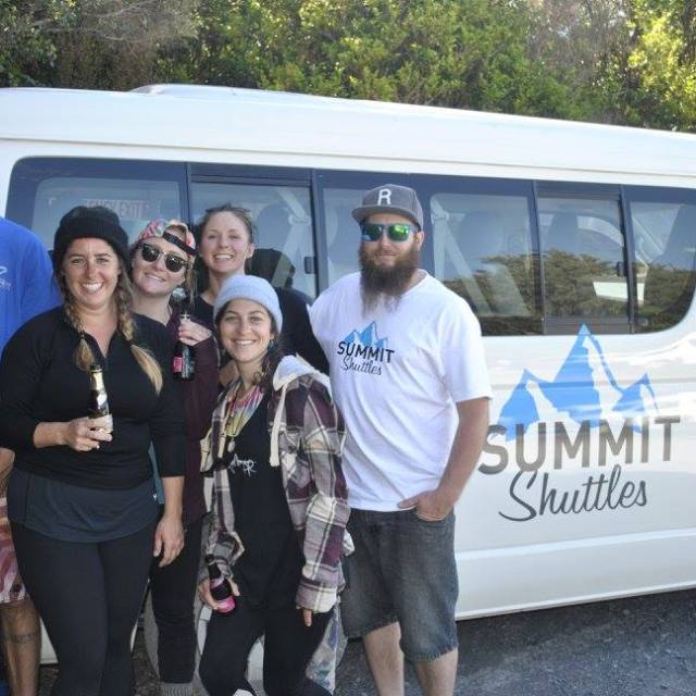 a group of people standing in front of a car posing for the camera